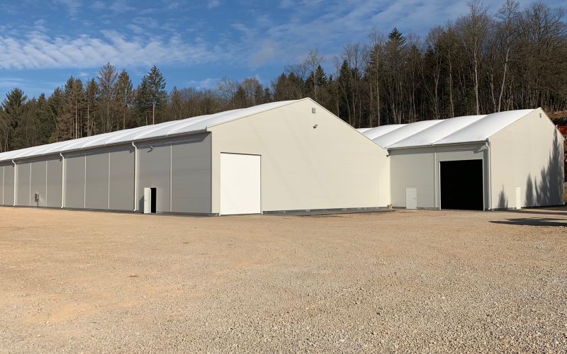Zwei fertiggstellte Lagerhallen mit Membrandrächern in der Seitenansicht
